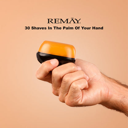 Hand holding a black and orange REMAY shaving cream gel for men with REMAY branding and text on a beige background that reads "30 haves in the palm of your hand"
