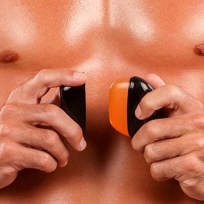 Close-up of a man holding a black and orange REMAY Heat shaving cream for men gel bar near abdomen.