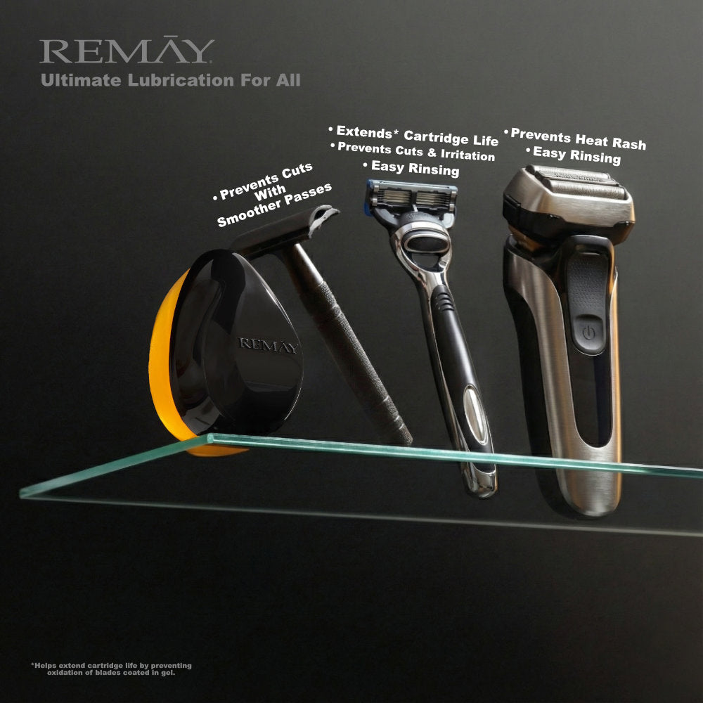 REMAY Heat shaving cream for men gel bar product next to a safety razor, a cartridge razor and an electric shaver on a glass shelf against a black background.