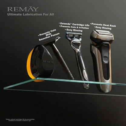 REMAY Heat shaving cream for men gel bar product next to a safety razor, a cartridge razor and an electric shaver on a glass shelf against a black background.